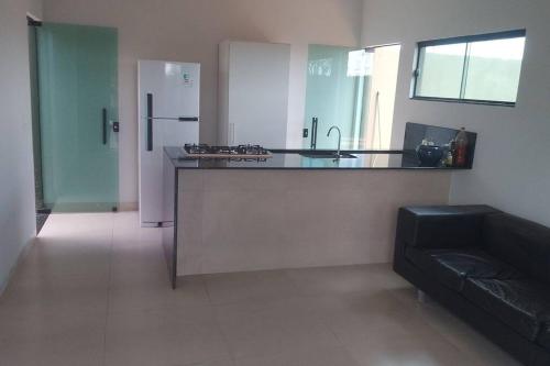 MaracajuにあるCasa super-aconchegante.のカウンターと冷蔵庫のあるキッチン