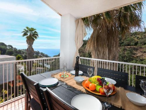 a table with a bowl of fruit on a balcony at Holiday Home Escorpio-1 by Interhome in Tossa de Mar