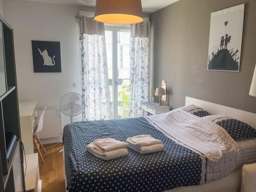 une chambre avec un lit avec deux serviettes dessus dans l'établissement Bel appartement spacieux / Proche Arena Paris Sud, à Issy-les-Moulineaux