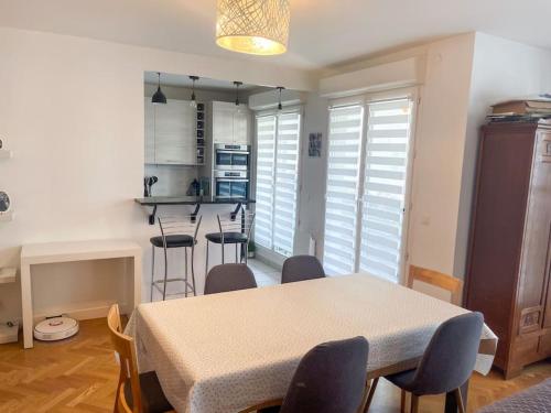 une cuisine et une salle à manger avec une table et des chaises dans l'établissement Bel appartement spacieux / Proche Arena Paris Sud, à Issy-les-Moulineaux