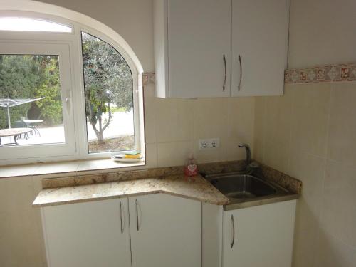 eine Küche mit einem Waschbecken und einem Fenster in der Unterkunft Tennis Villa Rosalia in Jávea