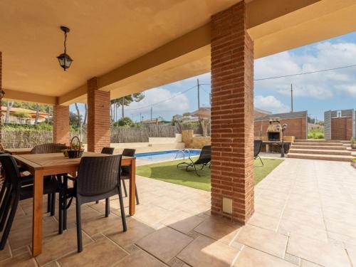 un patio con mesa, sillas y piscina en Holiday Home Jose Ramon by Interhome, en Vespellà