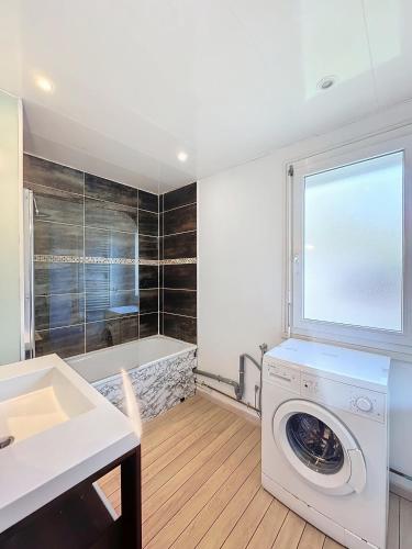 une buanderie avec une machine à laver et une fenêtre dans l'établissement Mémorial, à Caen