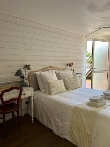 a bedroom with a bed with a desk and a bed sidx sidx sidx at Logis Hotel De La Clape in Narbonne-Plage