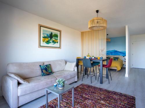 un salon avec un canapé et une table dans l'établissement Apartment Les Coralines by Interhome, à Villeneuve-Loubet