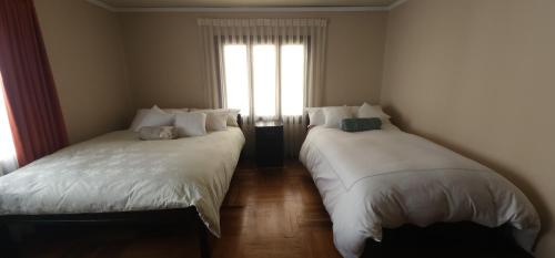two beds sitting in a room with a window at Raven La Paz in La Paz