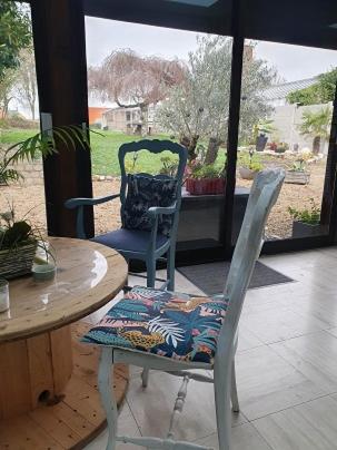 2 chaises assises à côté d'une table en bois, d'une table et d'une chaise dans l'établissement chez Marie et Patrick, à Chaulnes