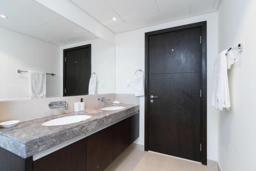 baño con 2 lavabos y espejo grande en Lux BnB Dubai Creek Harbour BLVD Views en Dubái
