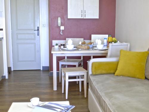 ein Wohnzimmer mit einem Tisch und einem Sofa in der Unterkunft Apartment Village Cap Estérel - Le Village-79 by Interhome in Agay - Saint Raphael