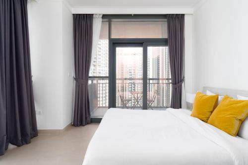 1 dormitorio con cama grande y ventana grande en Lux BnB Dubai Creek Harbour BLVD Views, en Dubái