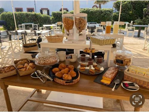 una mesa llena de diferentes tipos de pan y repostería en Canova LUXURY ROOMS A POCHI PASSI DAL CENTRO, en Favignana