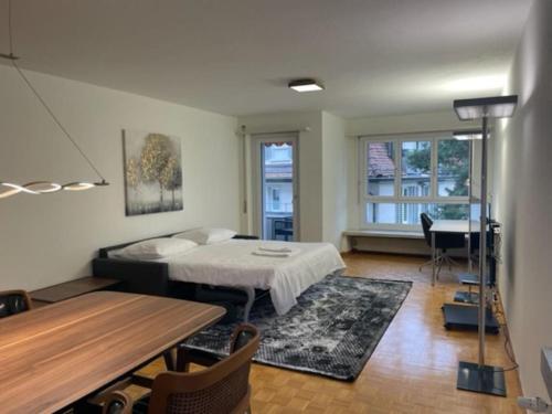 a room with a bed and a table and a piano at Cozy, sunny, city center 1 bedroom flat (Marble 3) in Zurich