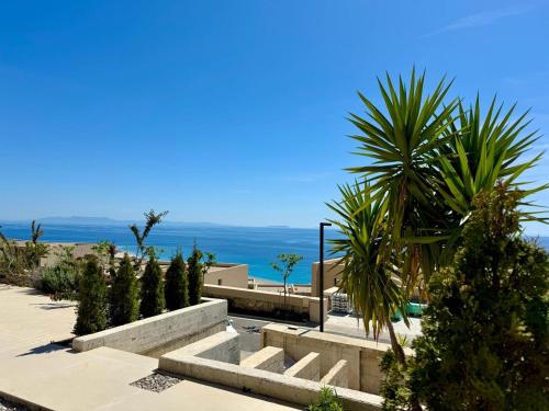 a view of the ocean from a resort with palm trees at Green Condo Hotel Palase in Himare