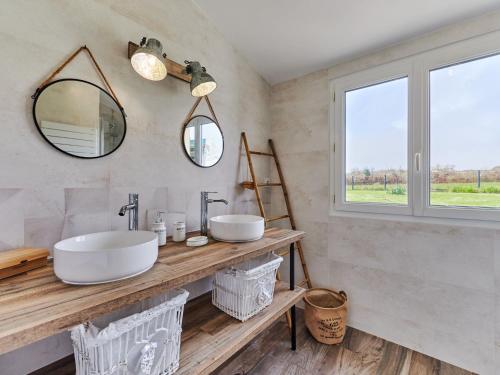 Un baño con dos lavabos y un espejo. en Holiday Home Le Hameau Boudet by Interhome, en Barneville-Carteret