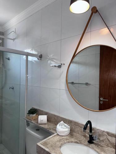 a bathroom with a sink and a mirror and a toilet at Fabika Pousada in Maragogi