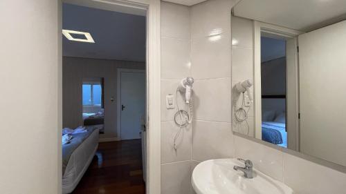 uma casa de banho com um lavatório e um espelho em Pousada Caracol em Canela