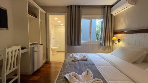 a bedroom with a large bed with a window at Pousada Golden Hills in Canela
