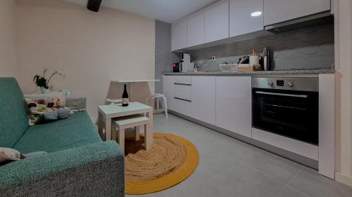 uma sala de estar com um sofá verde e uma cozinha em Solar de Pisões em Marco de Canavezes