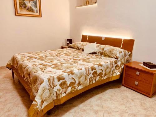 a bedroom with a bed and a wooden night stand at Anna&Franco Guest House in Isernia