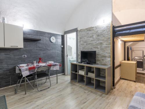 a kitchen with a table and a tv in a room at Holiday Home Kicca by Interhome in Sanremo