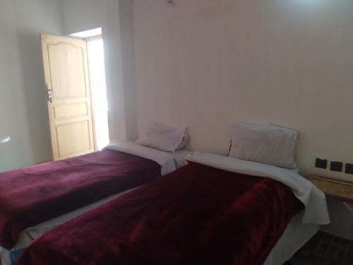 two beds sitting next to each other in a room at Hotel et Restaurant Riad Amodou in Tinerhir