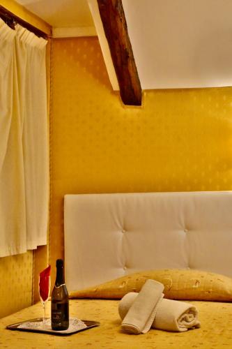 a table with a bottle and a glass of wine at Hotel Noemi in Venice
