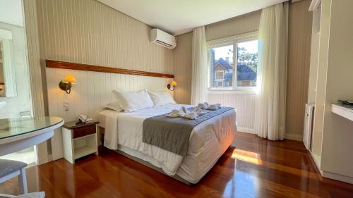 a hotel room with a bed and a window at Pousada Golden Hills in Canela
