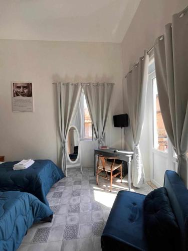 a bedroom with two beds and a desk and a mirror at Residenza La Meridiana in Briatico