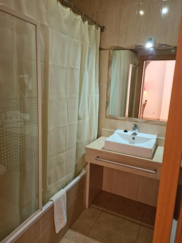 a bathroom with a sink and a shower at APARTAMENTOS CABRITA in Olhos de Água