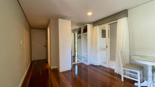 a room with a hallway with a sink and a table at Pousada Golden Hills in Canela