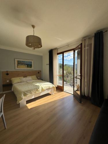 een slaapkamer met een bed en een glazen schuifdeur bij Bnb Castellane Chambre d'Hotes B&B in Castellane