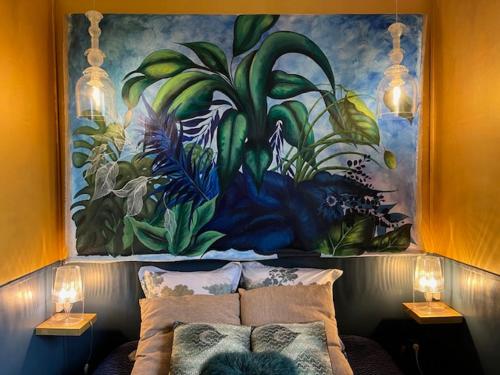 uma pintura na parede acima de uma cama num quarto em Chambres d'Hôtes & SPA Le Chat Chez Qui j'Habite em Saint-Aubin-sur-Mer