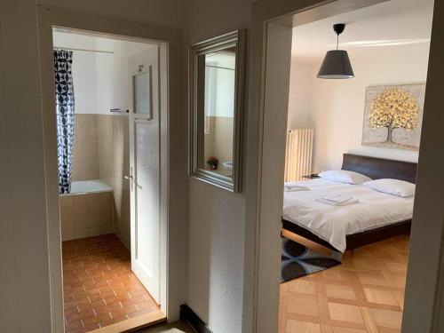 a bedroom with a bed and a bathroom with a tub at Sunny studio in the city center (Oken1) in Zürich