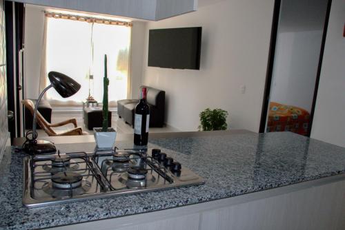 a bottle of wine sitting on top of a stove in a kitchen at Apartamento Completo Perfecto in Cartago
