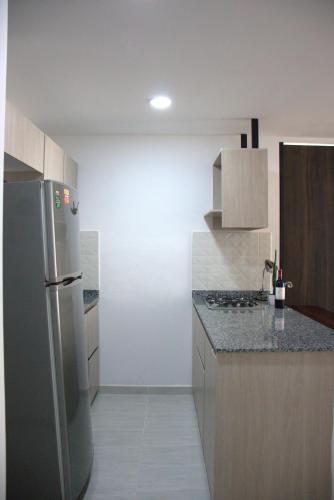 a kitchen with a stainless steel refrigerator and cabinets at Apartamento Completo Perfecto in Cartago