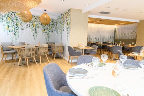 a restaurant with tables and chairs and a wall with flowers at ibis Styles Tours Centre in Tours