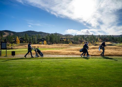 a group of three people walking on a golf course at Nesfjellet in Nes i Ådal