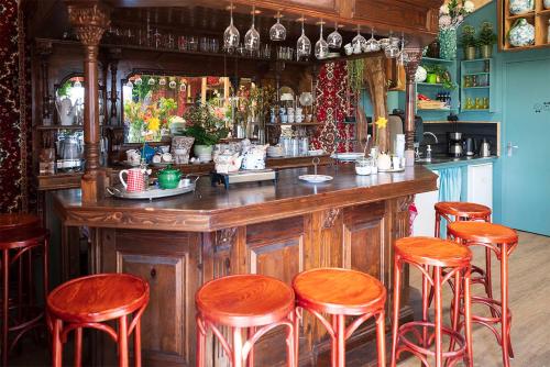 - un bar avec des tabourets en bois et un comptoir dans une pièce dans l'établissement Bloem & Bed, à Stolpen