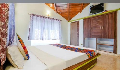 a bedroom with a large white bed with a window at Hotel Mint Resort in Jālna