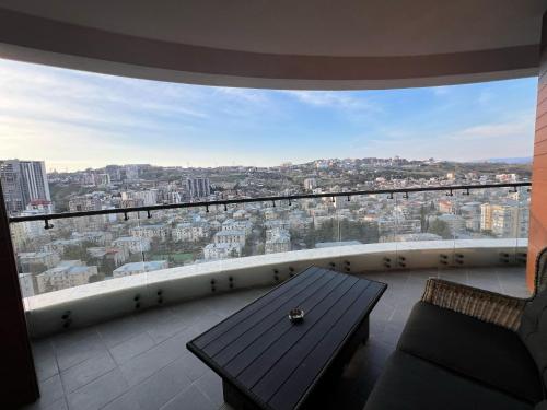 a balcony with a table and a view of a city at tbilisi garden 2 in Tbilisi City