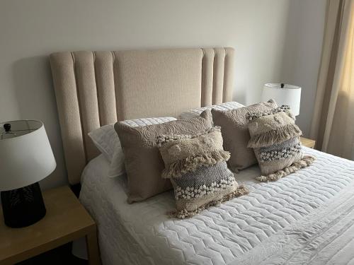 ein weißes Bett mit Kissen darüber in der Unterkunft Brantford King Bed Near it All in Brantford