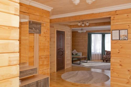 a living room with wooden walls and a door at Ski Paradise Karakol in Karakol