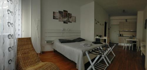 a bedroom with a bed and chairs in a room at Monolocale Fiera in Bologna