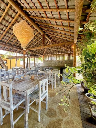 a dining room with a wooden table and chairs at Pousada Vento do Kite in Barra Grande