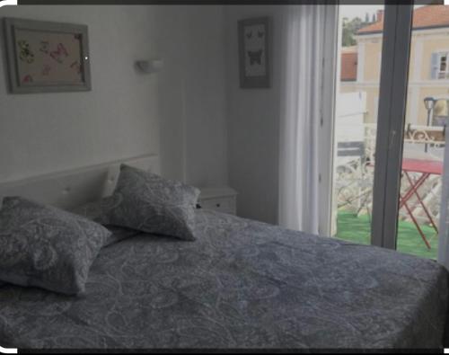 1 dormitorio con 1 cama con 2 almohadas y ventana en Luberon family, en Apt
