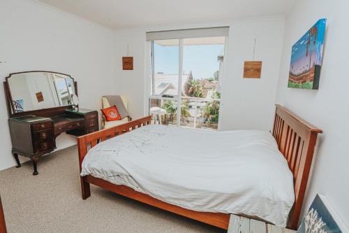 a bedroom with a bed and a mirror and a desk at The Sands - Convenient Location in Sydney