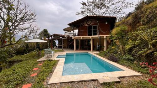 a house with a swimming pool in front of it at Casa Nutabe - Casa de Campo en Girardota cerca a Medellín in Girardota