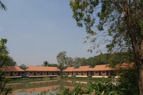 a row of buildings with trees in the foreground at Maewang Resort in Lampang