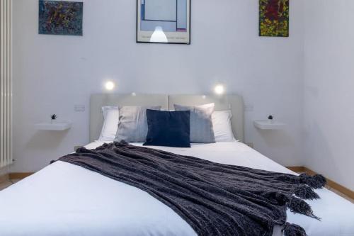 ein Schlafzimmer mit einem großen weißen Bett mit blauen Kissen in der Unterkunft [A due passi dal Castello] in Ferrara