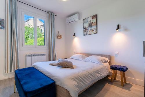 a bedroom with a large bed with a blue stool at Alta Vista , villa avec piscine privée et vue exceptionnelle près d'Ajaccio in Sarrola-Carcopino